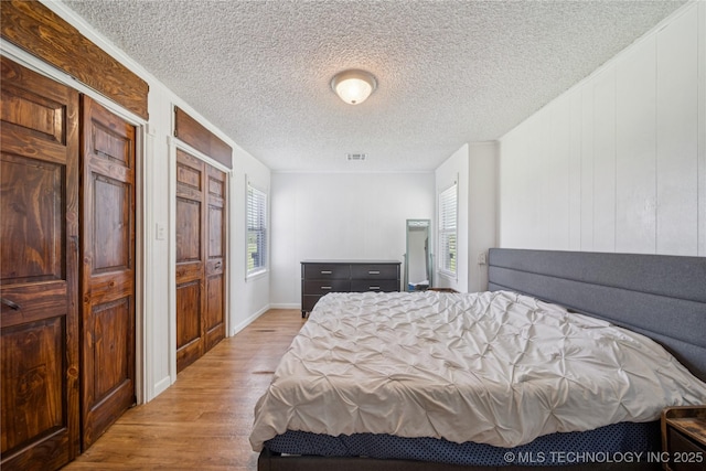 9025 N 156th Rd, Beggs, OK 74421 - bedroom featuring wood finished floors, multiple windows, and a textured ceiling