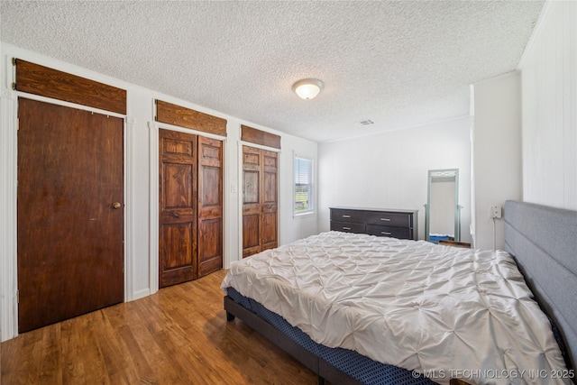 9025 N 156th Rd, Beggs, OK 74421 - bedroom with wood finished floors, a textured ceiling, and multiple closets