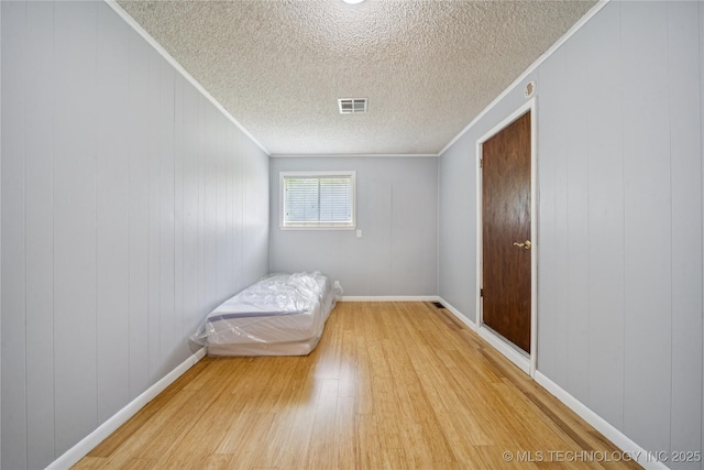 9025 N 156th Rd, Beggs, OK 74421 - bedroom featuring light wood-type flooring, ornamental molding, and a textured ceiling