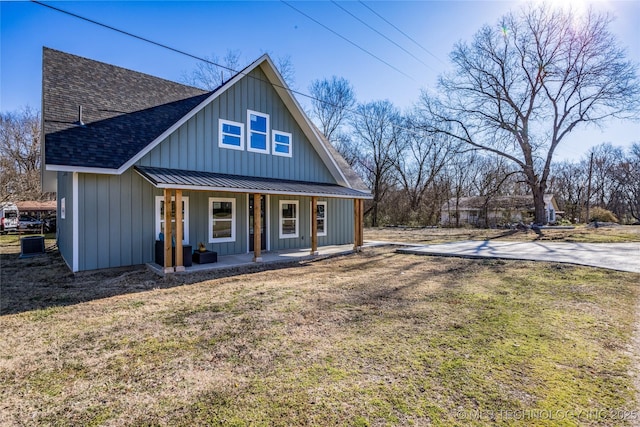 101 Dunn, Caddo, OK 74729 - view of front of house with covered porch, roof with shingles, board and batten siding, and a front lawn