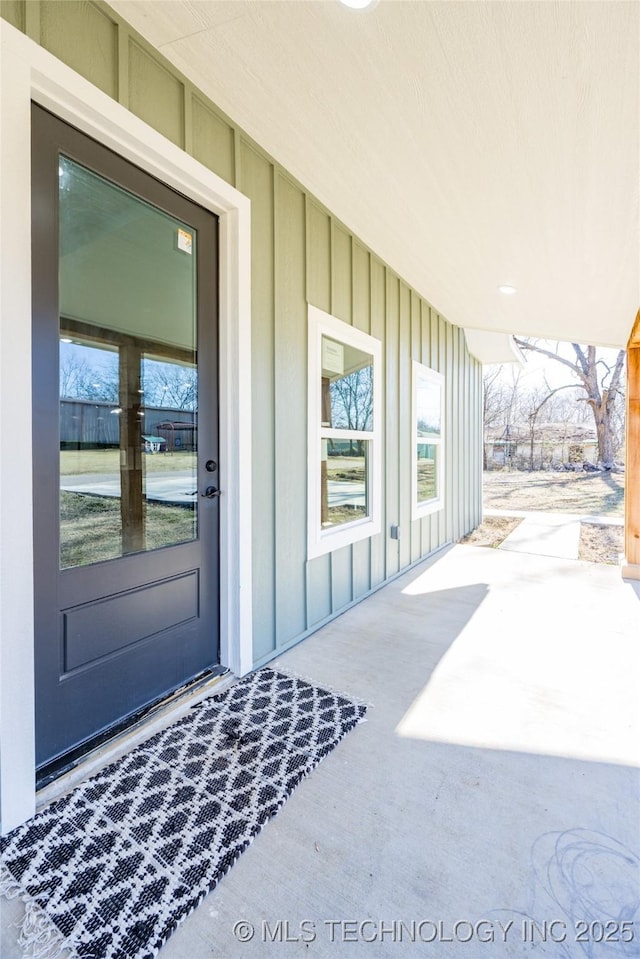 101 Dunn, Caddo, OK 74729 - view of exterior entry with board and batten siding and a patio