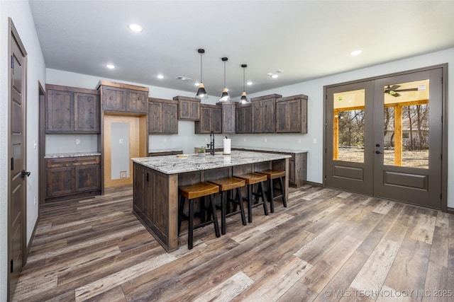 101 Dunn, Caddo, OK 74729 - kitchen featuring dark wood finished floors, a large island, french doors, recessed lighting, and dark brown cabinets