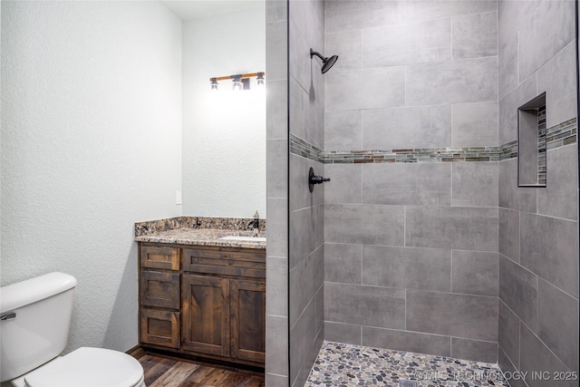 101 Dunn, Caddo, OK 74729 - full bath with a tile shower, wood finished floors, and vanity