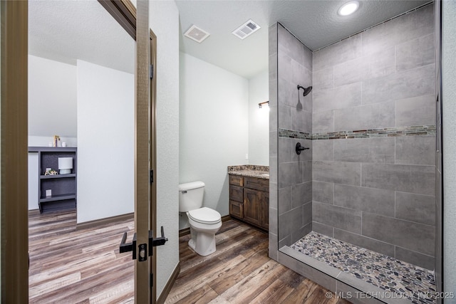 101 Dunn, Caddo, OK 74729 - bathroom featuring vanity, tiled shower, and wood finished floors