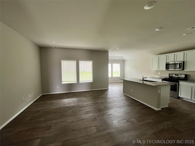 3118 SE Talimena Ct, Bartlesville, OK 74006 - kitchen with stainless steel appliances, open floor plan, dark wood-style floors, white cabinets, and recessed lighting