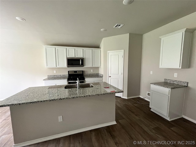 3118 SE Talimena Ct, Bartlesville, OK 74006 - kitchen with stainless steel microwave, dark wood-style flooring, light stone counters, white cabinetry, and recessed lighting