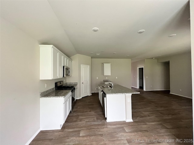 3118 SE Talimena Ct, Bartlesville, OK 74006 - kitchen with stainless steel appliances, white cabinets, dark wood-style floors, light stone counters, and a kitchen island with sink