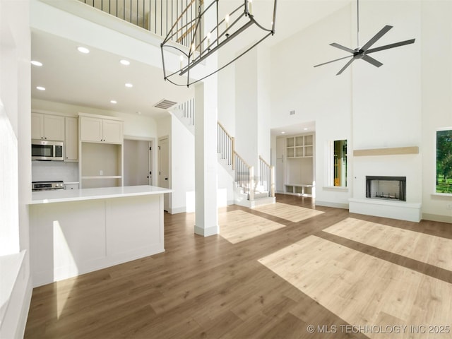 2 Valley View Dr, Burneyville, OK 73430 - unfurnished living room with a towering ceiling, wood finished floors, recessed lighting, stairs, and a ceiling fan