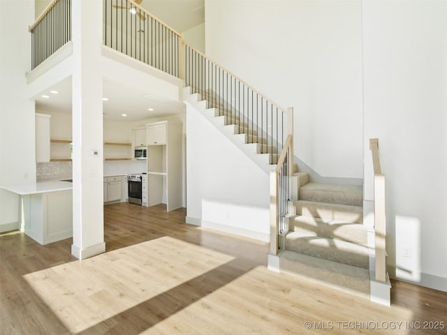 2 Valley View Dr, Burneyville, OK 73430 - stairs featuring wood finished floors, a high ceiling, and recessed lighting