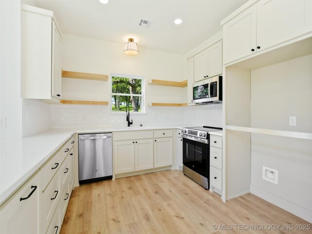 2 Valley View Dr, Burneyville, OK 73430 - kitchen featuring stainless steel appliances, open shelves, backsplash, light wood finished floors, and recessed lighting