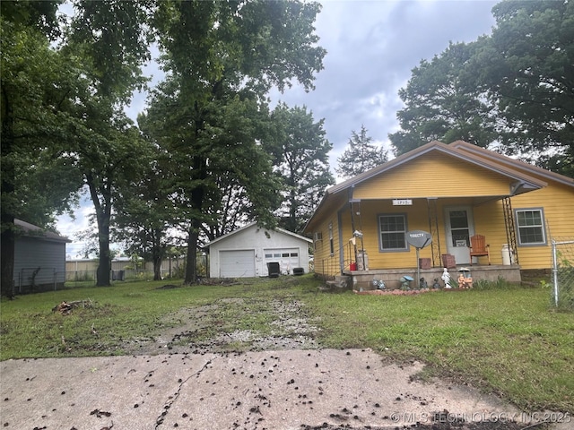 1315 W 5th St, Okmulgee, OK 74447 - bungalow featuring a garage, covered porch, and an outdoor structure