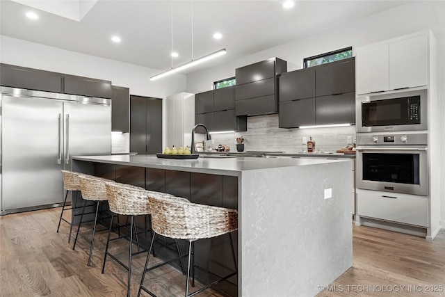 3008 S Boston Ct, Tulsa, OK 74114 - kitchen with built in appliances, modern cabinets, light wood finished floors, decorative backsplash, and recessed lighting