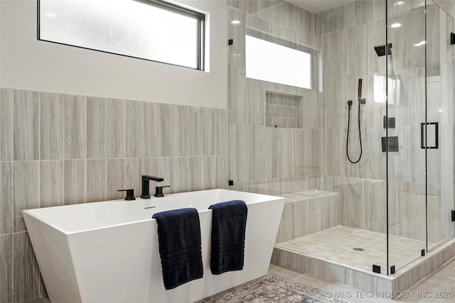 3008 S Boston Ct, Tulsa, OK 74114 - full bathroom with tile walls, healthy amount of natural light, a shower stall, and a soaking tub