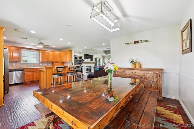 23535 E 720th Rd, Wagoner, OK 74467 - dining space featuring recessed lighting, dark wood finished floors, a glass covered fireplace, and ceiling fan