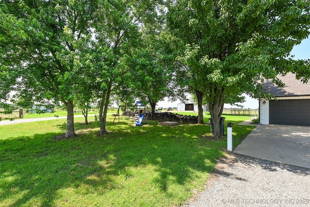 23535 E 720th Rd, Wagoner, OK 74467 - view of green lawn featuring concrete driveway, a playground, and a garage