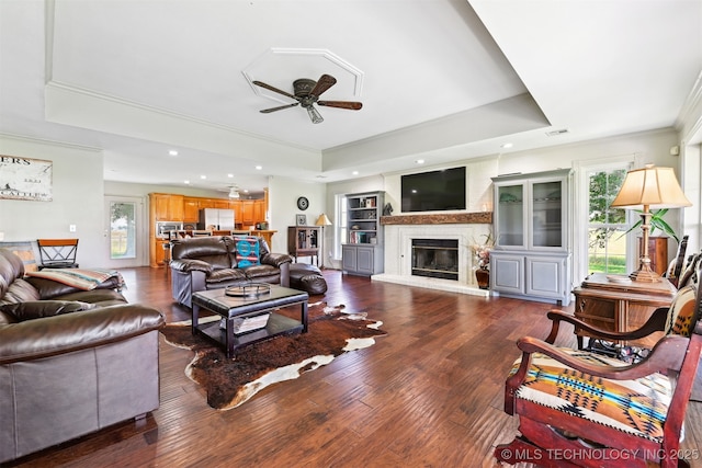 23535 E 720th Rd, Wagoner, OK 74467 - living room featuring a raised ceiling, ceiling fan, crown molding, wood finished floors, and a glass covered fireplace