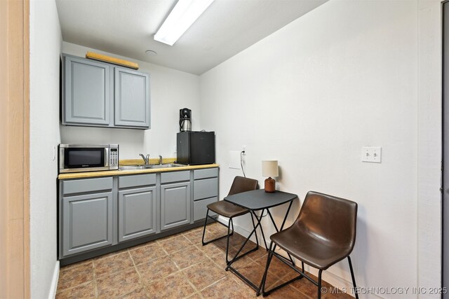 23535 E 720th Rd, Wagoner, OK 74467 - kitchen with gray cabinetry and stainless steel microwave