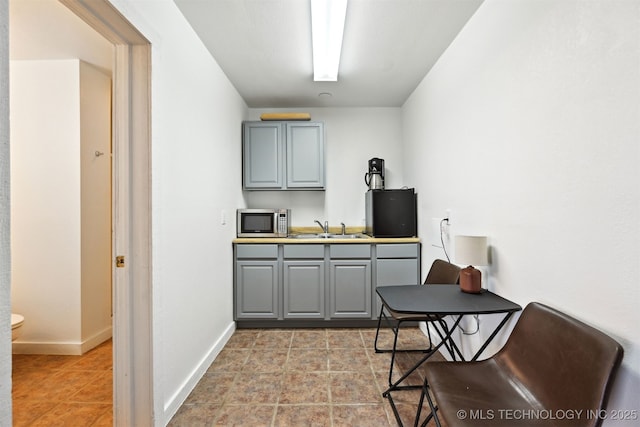 23535 E 720th Rd, Wagoner, OK 74467 - kitchen with stainless steel microwave, gray cabinetry, and light tile patterned flooring