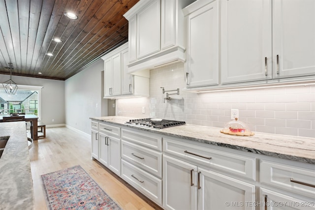 11325 S 212th E Ave, Broken Arrow, OK 74014 - kitchen with wooden ceiling, white cabinets, stainless steel gas stovetop, light wood-style flooring, and tasteful backsplash