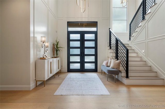 6026 E 119th Pl, Tulsa, OK 74137 - foyer featuring stairs, wood finished floors, a decorative wall, french doors, and a towering ceiling