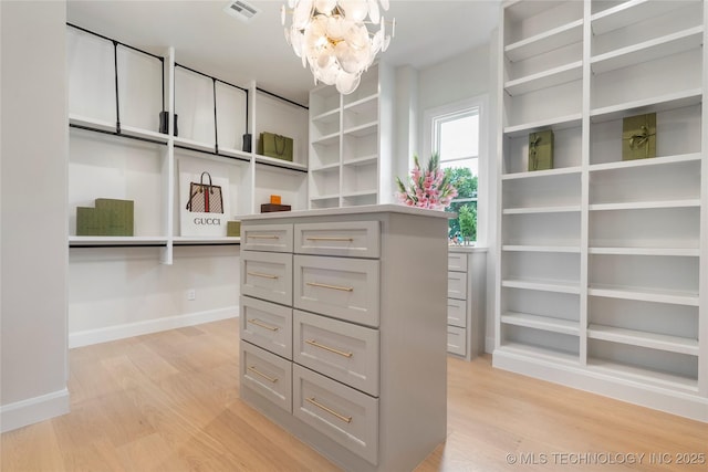 6026 E 119th Pl, Tulsa, OK 74137 - walk in closet with a chandelier and light wood-style floors