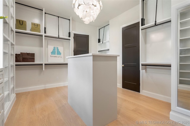 6026 E 119th Pl, Tulsa, OK 74137 - walk in closet featuring light wood-style flooring and a chandelier