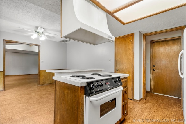 911 N Fir St, Jenks, OK 74037 - kitchen with white electric range, custom range hood, brown cabinets, light wood-style flooring, and a textured ceiling
