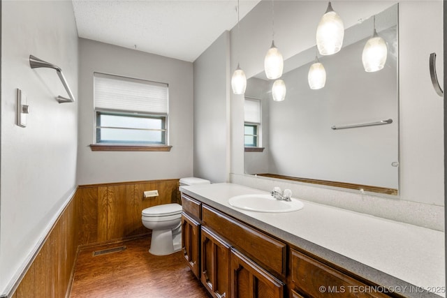 911 N Fir St, Jenks, OK 74037 - bathroom featuring a wainscoted wall, wood finished floors, plenty of natural light, vanity, and wood walls