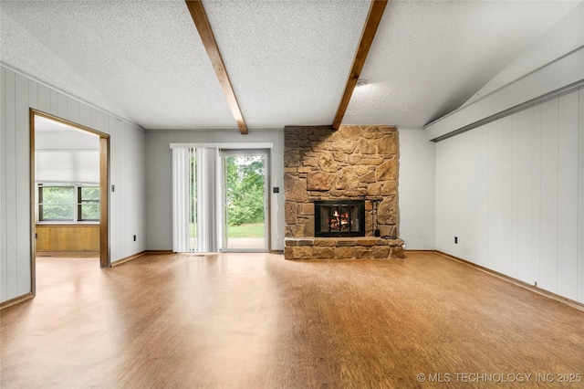 911 N Fir St, Jenks, OK 74037 - unfurnished living room with wood finished floors, healthy amount of natural light, a fireplace, beamed ceiling, and a textured ceiling