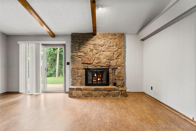 911 N Fir St, Jenks, OK 74037 - unfurnished living room with beamed ceiling, a stone fireplace, a textured ceiling, and wood finished floors