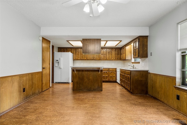 911 N Fir St, Jenks, OK 74037 - kitchen with white appliances, wood finished floors, wainscoting, a center island, and wooden walls