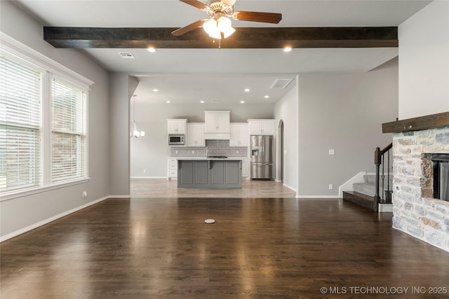12913 S Ash St, Jenks, OK 74037 - unfurnished living room featuring beam ceiling, a ceiling fan, stairs, wood finished floors, and recessed lighting