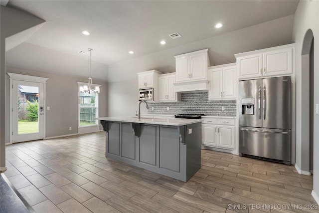 12913 S Ash St, Jenks, OK 74037 - kitchen featuring appliances with stainless steel finishes, a chandelier, white cabinetry, backsplash, and custom exhaust hood