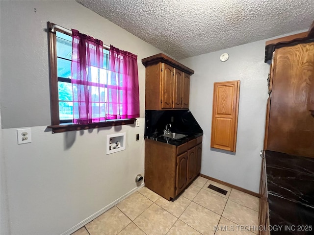619 W 4th St, Skiatook, OK 74070 - laundry room featuring washer hookup, a textured ceiling, and light tile patterned floors
