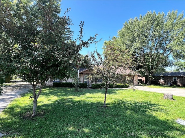 619 W 4th St, Skiatook, OK 74070 - view of property hidden behind natural elements with a front lawn
