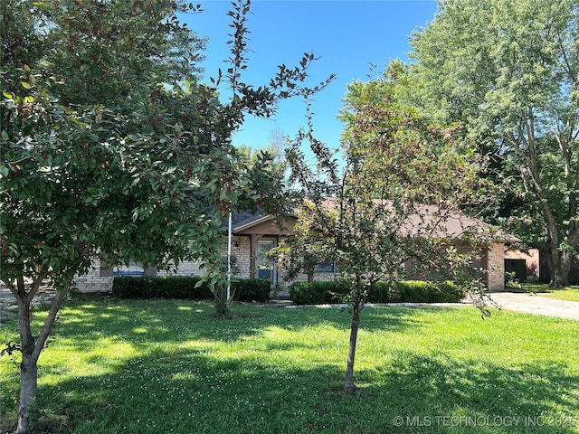 619 W 4th St, Skiatook, OK 74070 - obstructed view of property with a front yard, brick siding, and concrete driveway