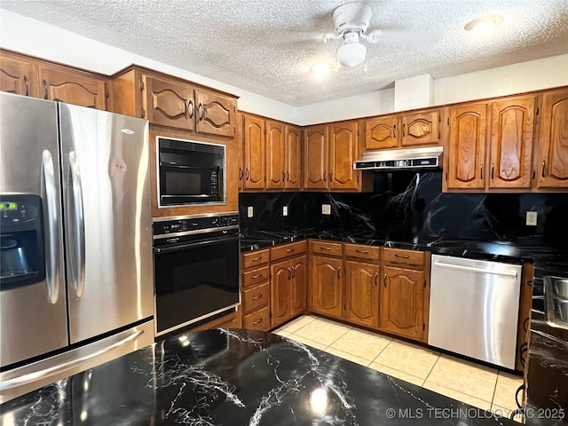 619 W 4th St, Skiatook, OK 74070 - kitchen featuring black appliances, brown cabinetry, backsplash, under cabinet range hood, and a textured ceiling