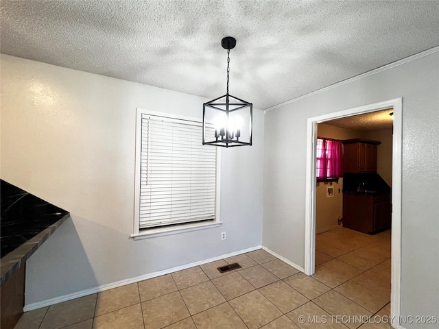 619 W 4th St, Skiatook, OK 74070 - unfurnished dining area with tile patterned floors, a chandelier, a textured ceiling, and ornamental molding