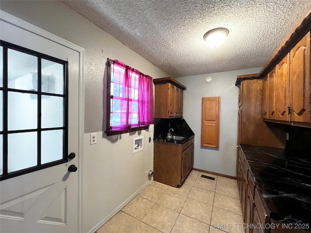 619 W 4th St, Skiatook, OK 74070 - laundry area featuring a textured ceiling, washer hookup, and light tile patterned floors