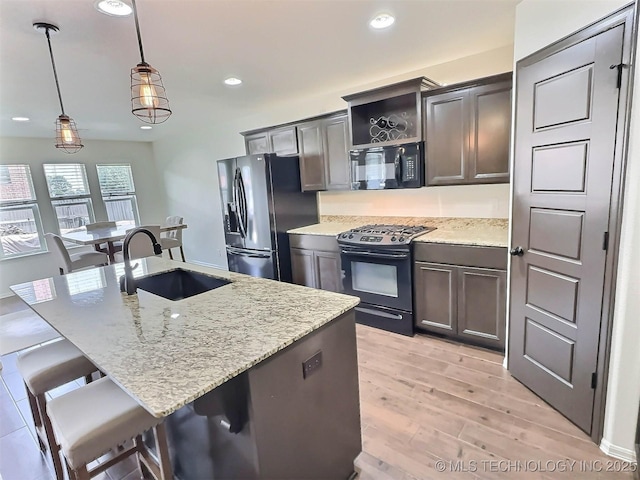 14603 E 114th St, Owasso, OK 74055 - kitchen featuring black microwave, range with gas stovetop, stainless steel fridge, light wood-style floors, and hanging light fixtures