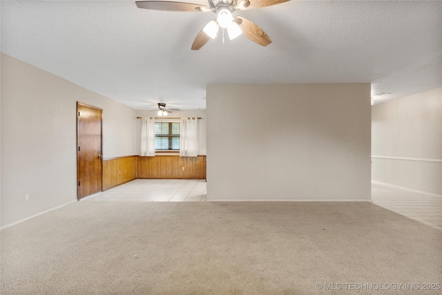 816 N Birch St, Jenks, OK 74037 - unfurnished living room with light colored carpet, ceiling fan, wood walls, wainscoting, and a textured ceiling