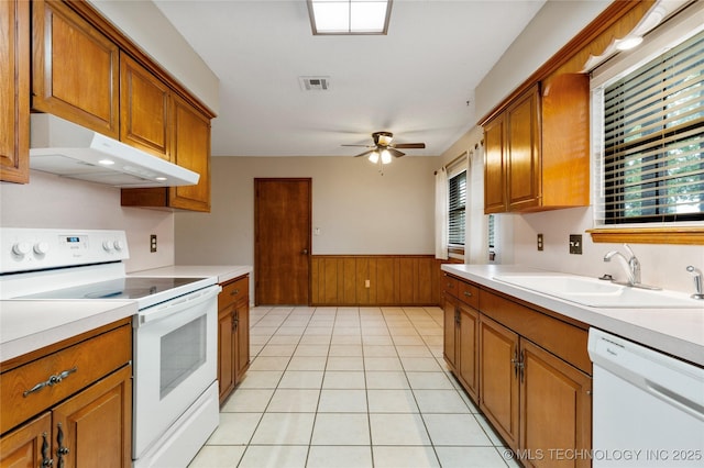 816 N Birch St, Jenks, OK 74037 - kitchen with white appliances, under cabinet range hood, brown cabinetry, light countertops, and wainscoting