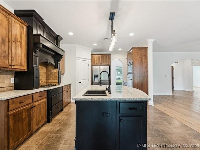 19345 S Fieldstone Dr E, Claremore, OK 74017 - kitchen with arched walkways, backsplash, a center island with sink, recessed lighting, and decorative light fixtures