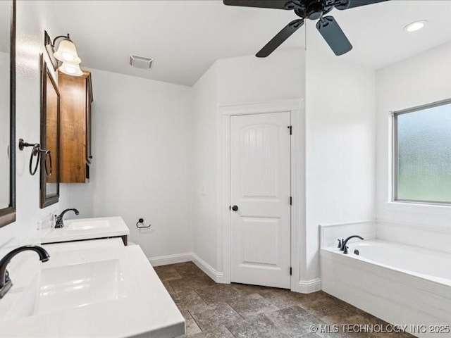 19345 S Fieldstone Dr E, Claremore, OK 74017 - full bathroom with a garden tub, double vanity, ceiling fan, stone finish flooring, and recessed lighting