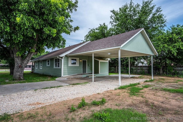 211 N 3rd St, Davis, OK 73030 - view of front of home featuring an attached carport, gravel driveway, and a shingled roof