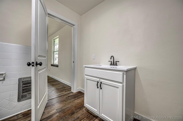 211 N 3rd St, Davis, OK 73030 - bathroom featuring heating unit, vanity, and wood finished floors