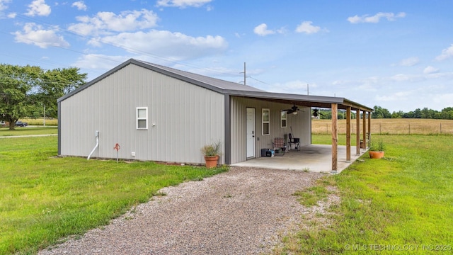 5499 S 4240th Rd, Chelsea, OK 74016 - view of side of home with ceiling fan, an attached carport, gravel driveway, and a patio area
