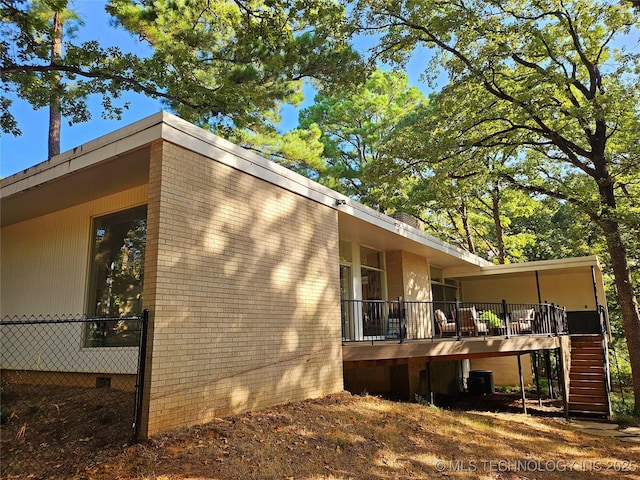 2417 Wilson St, Durant, OK 74701 - view of side of property with stairs, a deck, crawl space, and brick siding