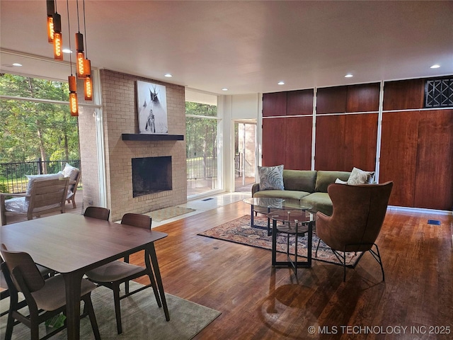 2417 Wilson St, Durant, OK 74701 - living area featuring wood finished floors, a brick fireplace, and recessed lighting
