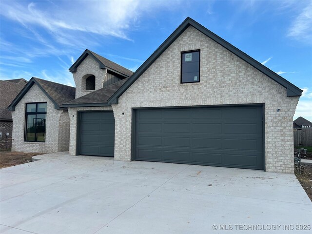 23191 E 107th St, Broken Arrow, OK 74014 - view of front facade with brick siding, roof with shingles, a garage, and concrete driveway